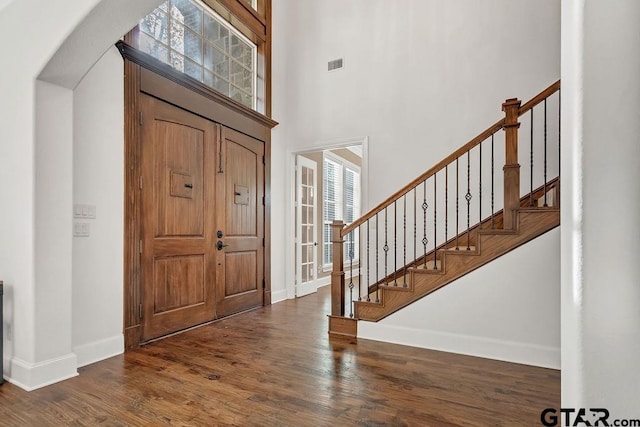 foyer entrance with a high ceiling and dark hardwood / wood-style flooring