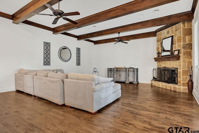 living room with beam ceiling, dark hardwood / wood-style flooring, a stone fireplace, and ceiling fan