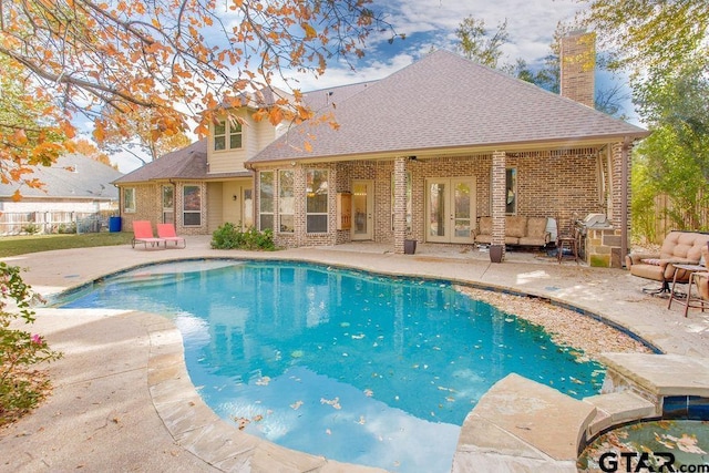 view of swimming pool featuring french doors and a patio