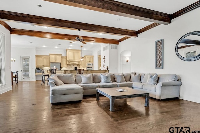 living room featuring ceiling fan, beamed ceiling, dark hardwood / wood-style floors, and ornamental molding