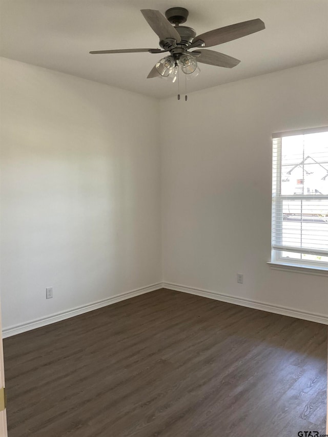 empty room with ceiling fan and dark hardwood / wood-style floors