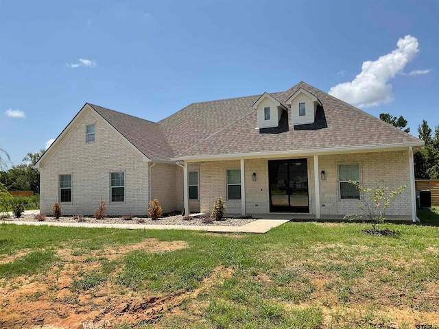 view of front of property featuring a front yard and cooling unit