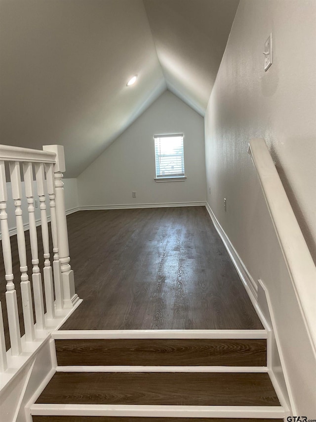 additional living space with dark wood-type flooring and lofted ceiling