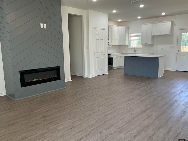 kitchen featuring a wealth of natural light, white cabinetry, and stainless steel electric range oven