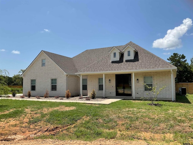 rear view of property with a lawn and central AC