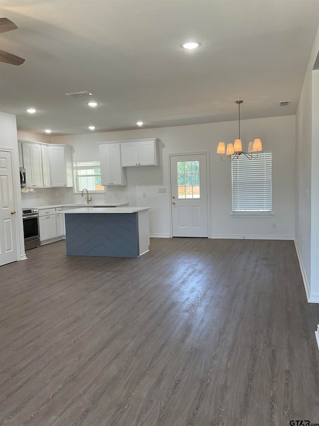 kitchen with pendant lighting, stainless steel appliances, white cabinetry, and a healthy amount of sunlight