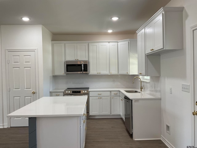 kitchen featuring stainless steel appliances, a kitchen island, dark hardwood / wood-style floors, sink, and white cabinets