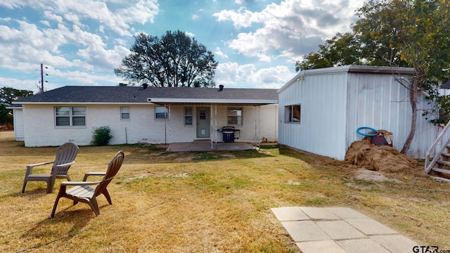 rear view of property featuring a lawn and a patio area