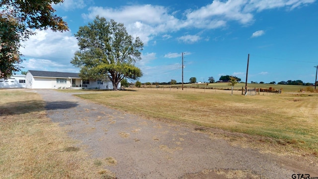 view of front of home with a rural view and a front yard