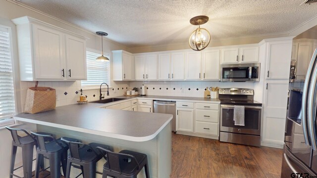 9497 Fm 804, Larue, TX 75770 - kitchen with stainless steel appliances, a sink, a peninsula, a textured ceiling, and white cabinets