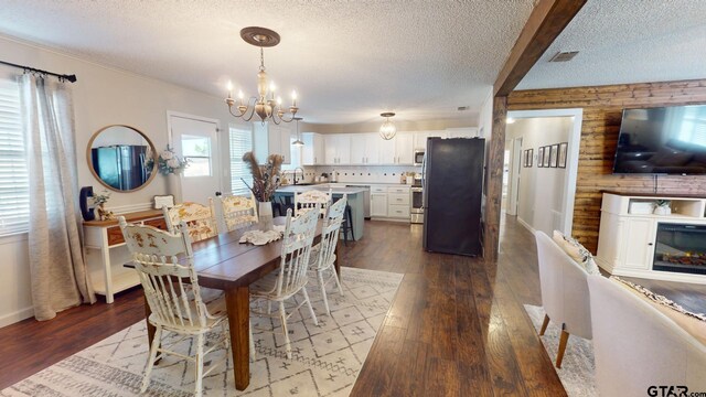 9497 Fm 804, Larue, TX 75770 - dining area with a chandelier, a textured ceiling, and dark wood-style floors