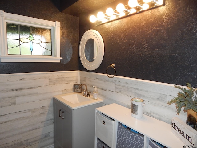 bathroom with wood walls and vanity