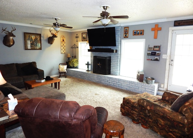 carpeted living room featuring a fireplace, ceiling fan, a textured ceiling, and ornamental molding