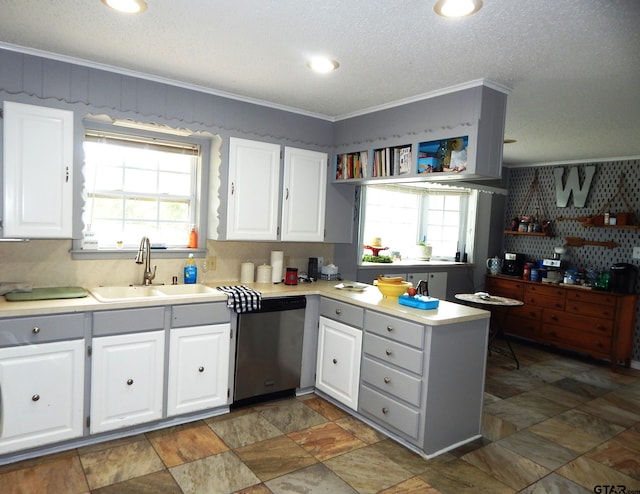 kitchen featuring a healthy amount of sunlight, sink, dishwasher, and white cabinets