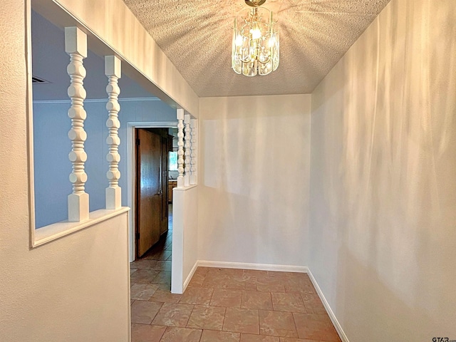 hall with stone tile flooring, baseboards, an inviting chandelier, and a textured ceiling