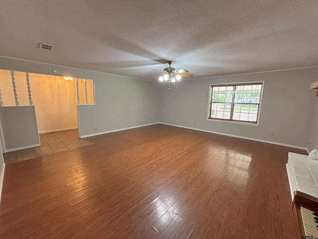spare room with visible vents, baseboards, wood finished floors, and ceiling fan