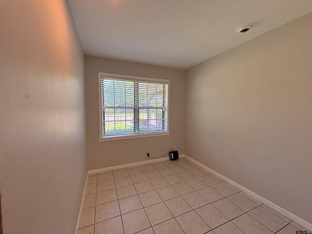 unfurnished room featuring light tile patterned floors and baseboards