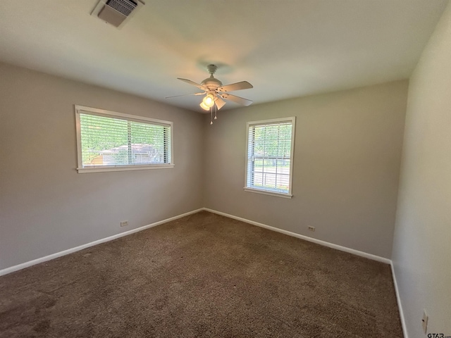 empty room with a wealth of natural light, visible vents, and baseboards