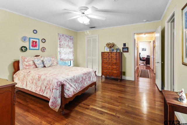 bedroom featuring ceiling fan, ornamental molding, dark wood-type flooring, and a closet