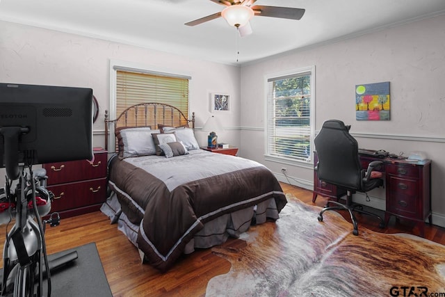 bedroom with hardwood / wood-style flooring, ceiling fan, and crown molding