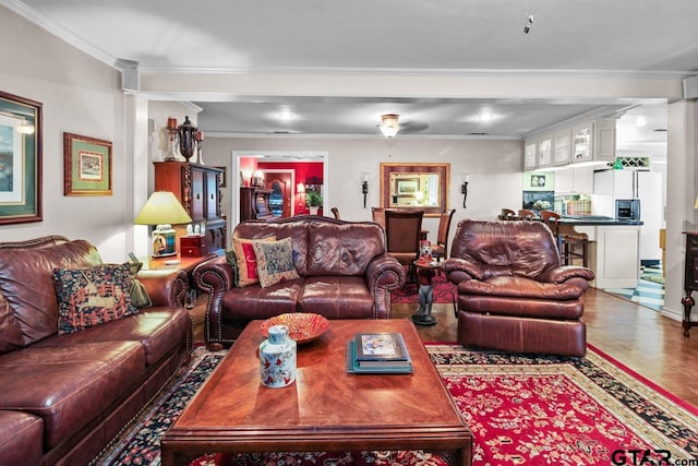 living room with crown molding, ceiling fan, and hardwood / wood-style flooring