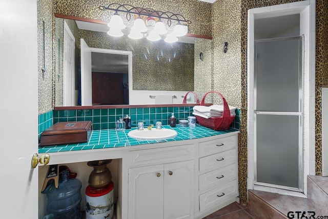 bathroom featuring tile patterned floors, decorative backsplash, vanity, and an enclosed shower