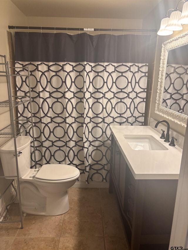 bathroom featuring vanity, tile patterned floors, and toilet