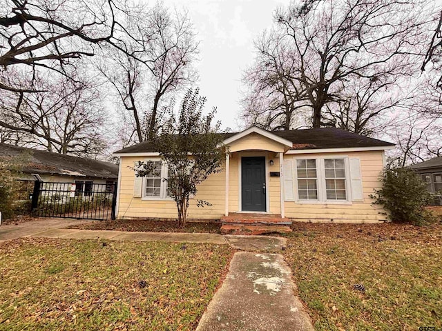 bungalow-style home featuring a front lawn