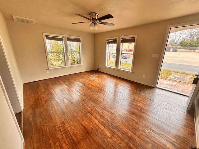 spare room with wood-type flooring, a healthy amount of sunlight, and ceiling fan