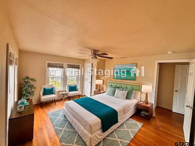 bedroom featuring wood-type flooring, a textured ceiling, and ceiling fan