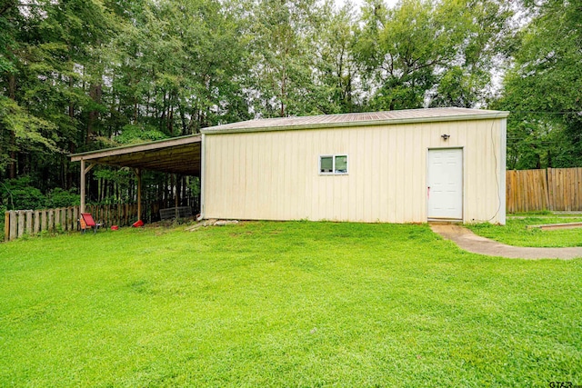 view of outbuilding featuring a yard and a carport