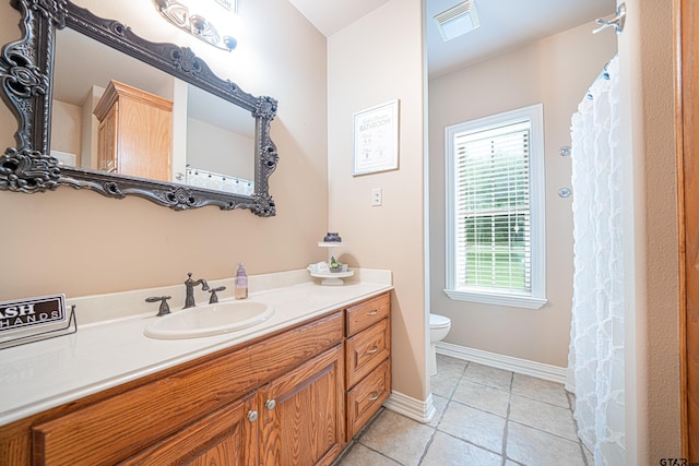 bathroom with tile patterned flooring, vanity, and toilet