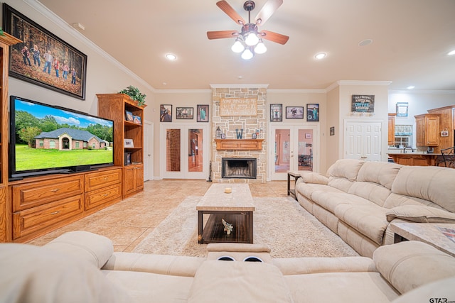 tiled living room featuring a stone fireplace, french doors, ceiling fan, and crown molding