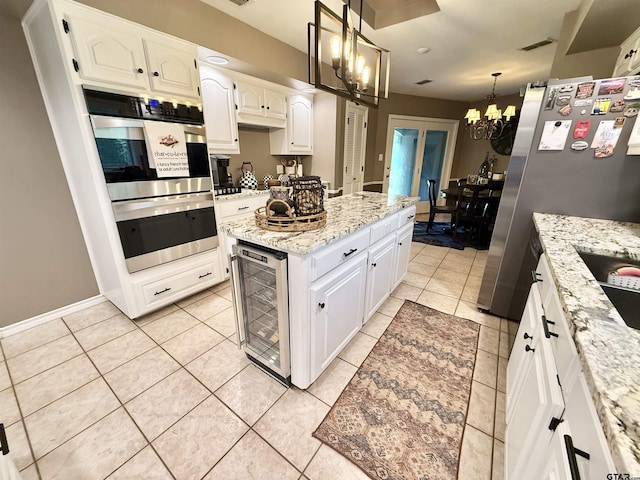 18872 Big Timber Rd, Tyler, TX 75703 - kitchen with beverage cooler, a chandelier, white cabinetry, light stone counters, and decorative light fixtures