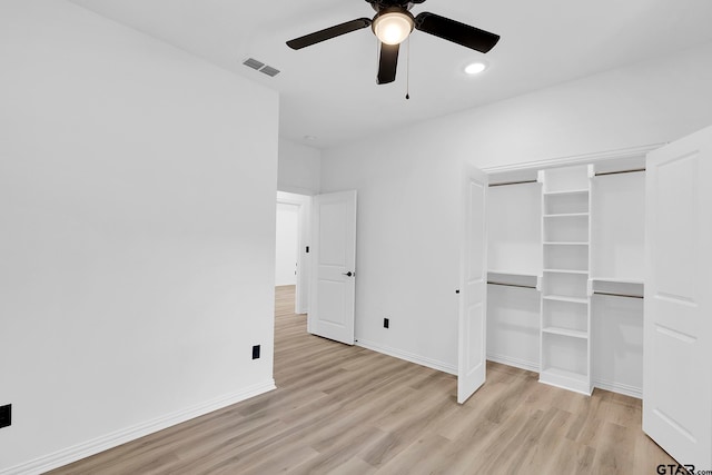 unfurnished bedroom featuring ceiling fan, a closet, and light wood-type flooring