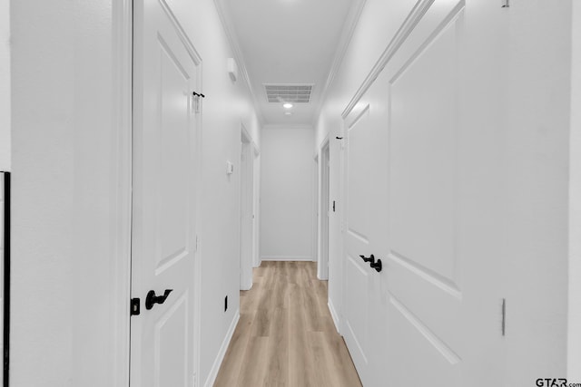 corridor featuring light hardwood / wood-style flooring and crown molding