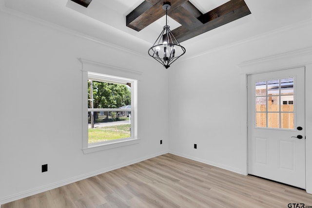 unfurnished dining area with coffered ceiling, a chandelier, ornamental molding, and light hardwood / wood-style flooring