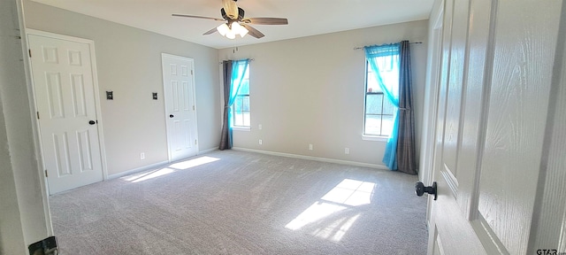unfurnished bedroom featuring baseboards, light colored carpet, and ceiling fan