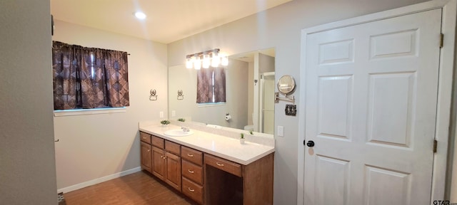 full bathroom featuring toilet, baseboards, wood finished floors, and vanity