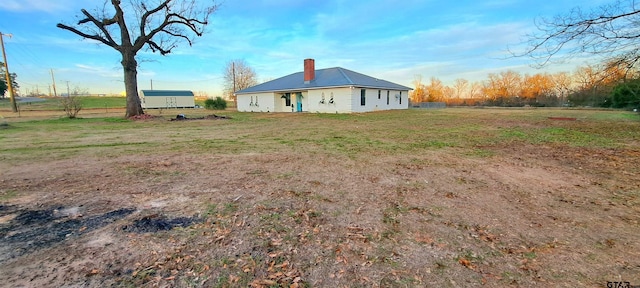 rear view of house with a yard and a chimney