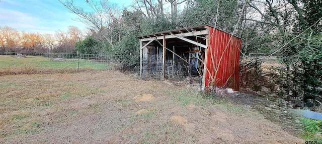 view of pole building featuring fence and a wooded view