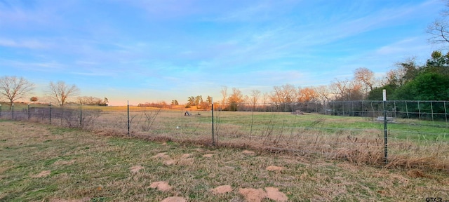 view of yard featuring fence and a rural view