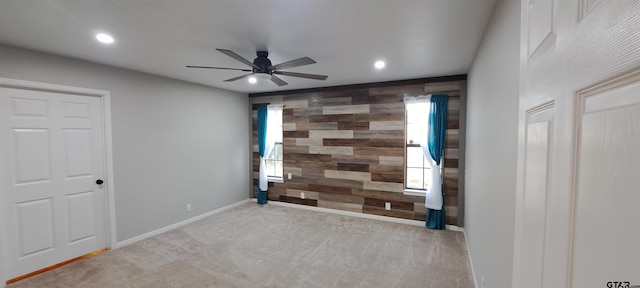 spare room with carpet flooring, recessed lighting, wood walls, and an accent wall