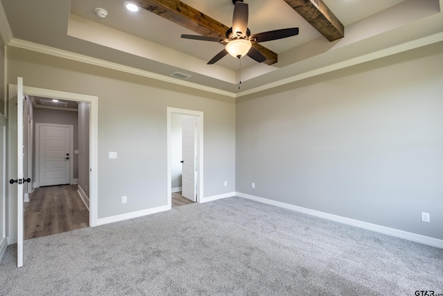 unfurnished bedroom featuring visible vents, baseboards, a ceiling fan, a tray ceiling, and carpet flooring