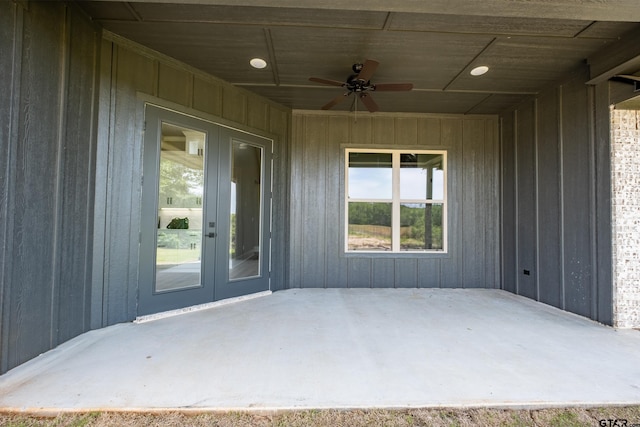 view of exterior entry with board and batten siding, a patio, french doors, and ceiling fan