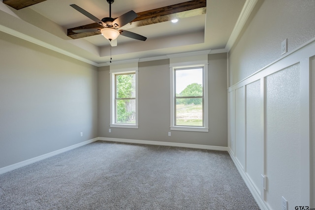 spare room featuring a raised ceiling, carpet flooring, baseboards, and a ceiling fan