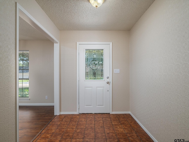 entryway with dark wood-type flooring and a textured ceiling