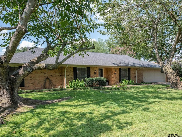 single story home featuring a garage and a front lawn