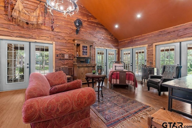 bedroom with high vaulted ceiling, multiple windows, access to outside, and french doors