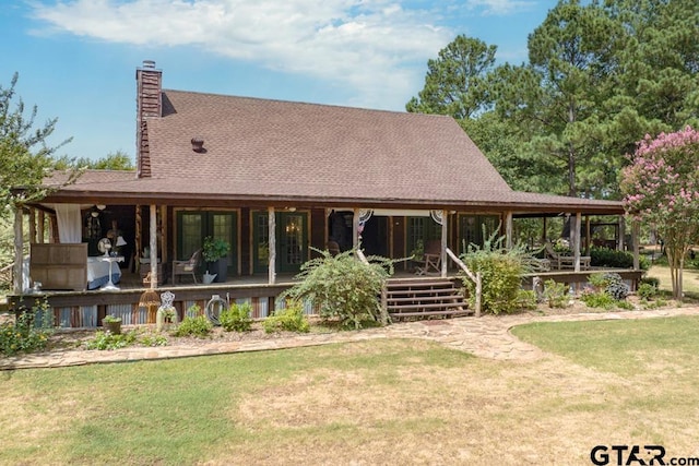 back of house with covered porch and a lawn